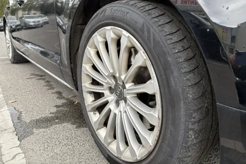 Melnas automa&scaron;īnas priek&scaron;ējais ritenis ar spīdīgu disku.