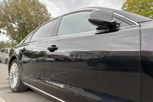 Melnas automa&scaron;īnas sānskats stāvvietā.