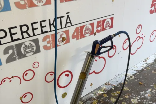 Mazgā&scaron;anas pistole ar &scaron;ļūteni, apkārt ziepju putas.