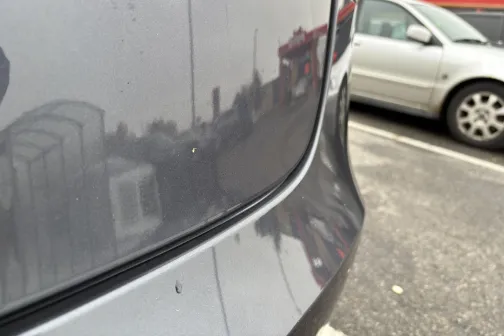 Pelēka automa&scaron;īna stāvvietā ar atspulgu.