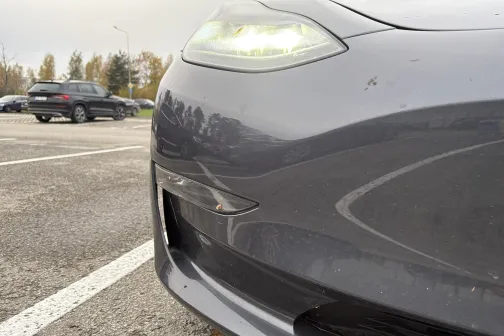 Automa&scaron;īnas priek&scaron;puse stāvvietā ar ieslēgtām priek&scaron;ējām gaismām.