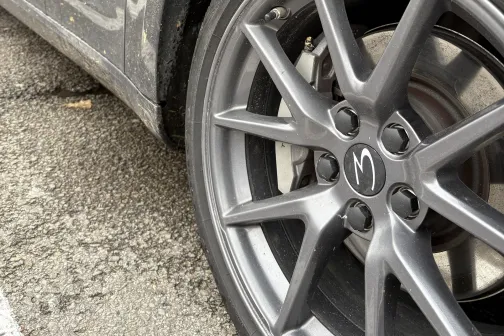 Tum&scaron;a automa&scaron;īna ar netīru priek&scaron;ējo riteni stāvvietā.