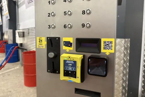 Metāla maksājumu automāts ar pogām un autostāvvietā.