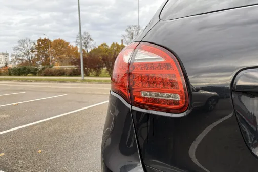 Melna automa&scaron;īna ar sarkanu aizmugurējo lukturi stāvvietā.