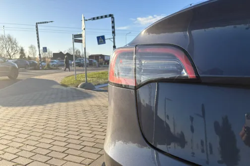 Tum&scaron;as automa&scaron;īnas aizmugure saulainā dienā stāvvietā.