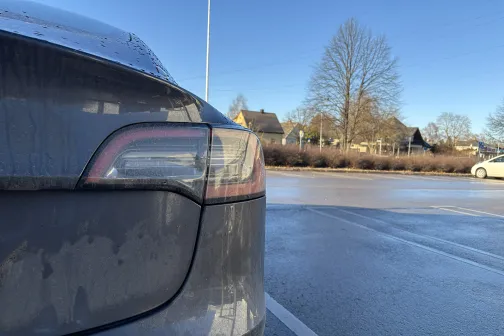 Putekļots auto stāvvietā, fonā koki.