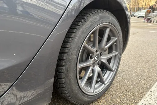 Pelēka automa&scaron;īna ar tīru aizmugurējo riteni pilsētas stāvvietā.