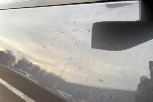 Netīrs automa&scaron;īnas sāns ar ūdens pēdām.