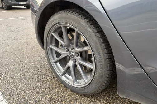 Auto aizmugurējais ritenis stāvvietā.