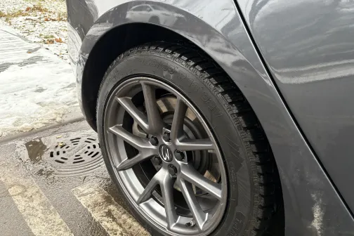 Sudraba automa&scaron;īnas ritenis uz slapja ziemas ceļa.