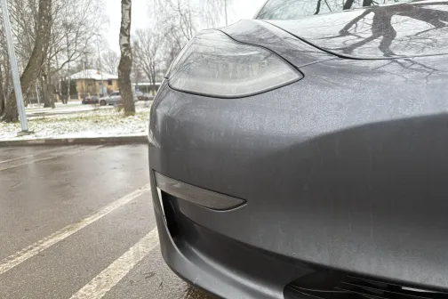 Netīrs pelēks auto ziemas laikā.