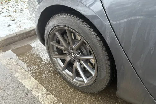 Pelēka automa&scaron;īna ar slapju un netīru aizmugurējo riepu.