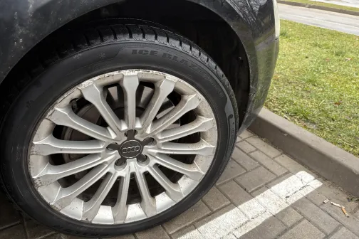 Auto ar netīriem sudraba diskiem, stāvvietā.