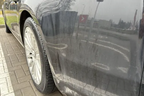 Netīrs auto sāns ar atspulgiem, stāvvietā.