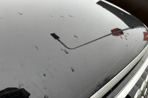 Auto priek&scaron;a ar netīrumiem un atspīdumu no ceļa zīmes.