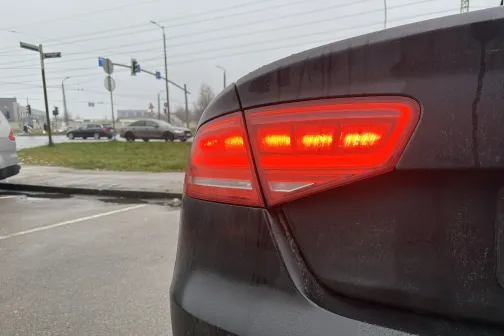 Auto aizmugurējais lukturis iedegts sarkans, pilsētas fons.