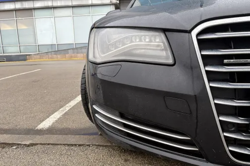 Melnas automa&scaron;īnas priek&scaron;puse pie stāvvietas.