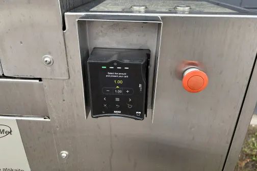 Maksājumu terminālis un poga paklāju tīrī&scaron;anas aparātam.