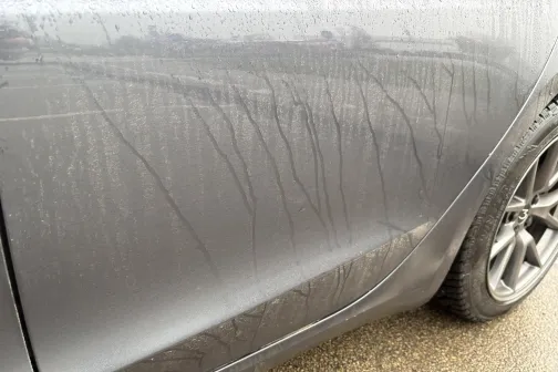 Netīrs automa&scaron;īnas sānskats ar slapjām &scaron;vīkām uz virsbūves.