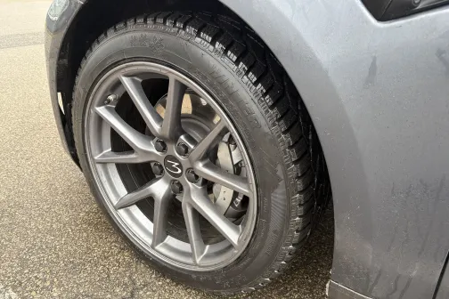 Sudraba automa&scaron;īnas ritenis uz slapjas asfalta.