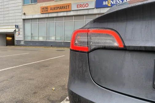 Pelēkas automa&scaron;īnas aizmugures lukturis pie ēkas.