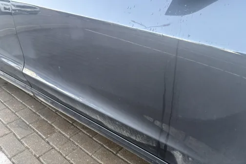 Netīra automa&scaron;īnas sānu durvju virsma stāvlaukumā.