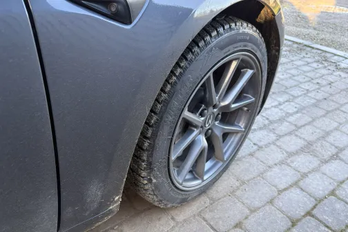 Melna automa&scaron;īnas ritenis uz bruģakmens ceļa.