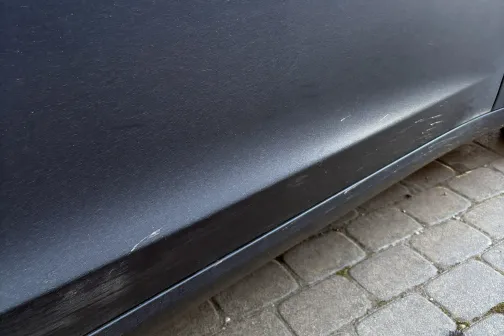 Netīras melnas automa&scaron;īnas sāns uz bruģa.