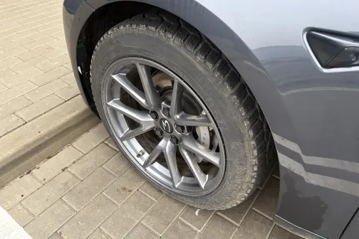 Auto dubļains ritenis uz bruģēta seguma.