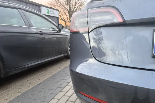 Divas netīras automa&scaron;īnas stāvvietā uz bruģa.