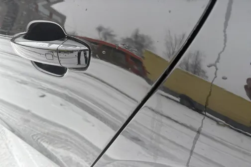 Spīdīgas automa&scaron;īnas virsma sniegotā vidē.