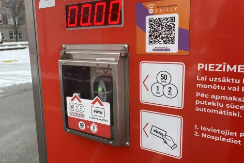 Putekļu sūcēja automāts ar maksājumu termināli un instrukcijām.