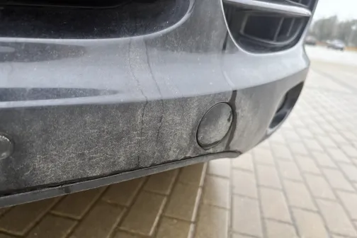 Netīrs automa&scaron;īnas priek&scaron;ējais bamperis uz bruģakmens.