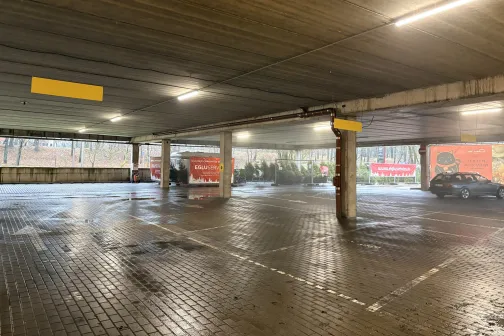 Tuk&scaron;a pazemes autostāvvieta ar reklāmas plakātiem.