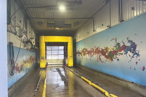 Automazgātavas telpa ar spilgti zilām un dzeltenām sienām.