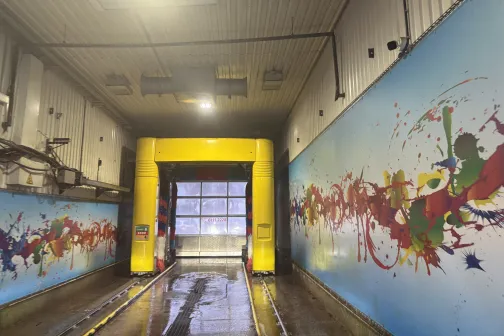 Automa&scaron;īnu mazgātavas interjers ar krāsainām sienām un dzeltenu iekārtu.