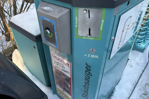 Monētu automāts automazgātuves laukā ziemā.