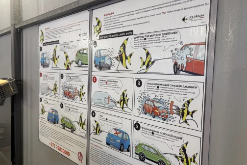 Instrukciju plakāts automazgātavā ar auto zīmējumiem un bultām.