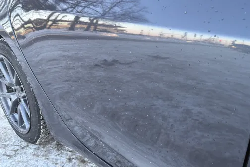 Netīrs auto sānu durvis ziemas ainavā.