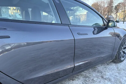 Netīra melna automa&scaron;īna uz sniegota ielas.