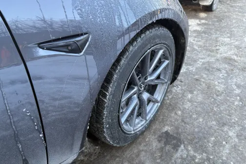 Pelēka automa&scaron;īna ar netīru priek&scaron;ējo riteni ziemā.