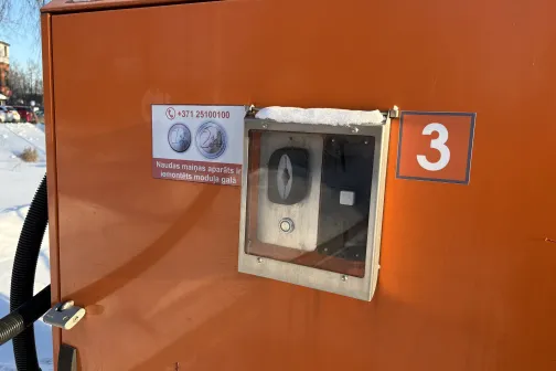 Oranžs automazgātavas numurs 3 ar kontrolpaneli un sniegu.