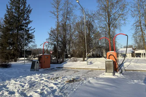 Sniegota automazgātuve ar sarkaniem tīrī&scaron;anas sūkņiem un kokiem fonā.