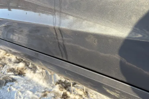 Netīrs auto sānskats ar dubļiem un sniegu.