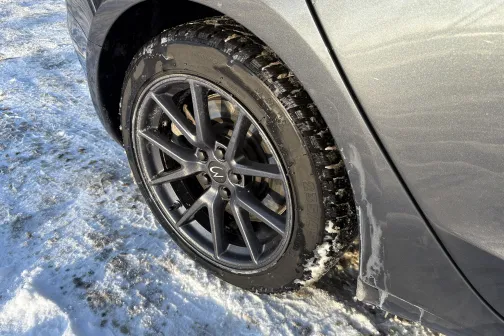 Auto ritenis uz sniegota ceļa, sudraba krāsa.