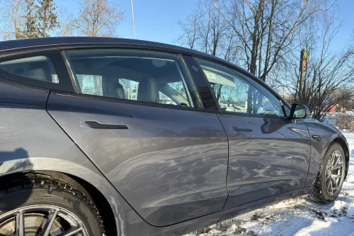 Tum&scaron;sauto ziemas dienā ar sniegu uz zemes.