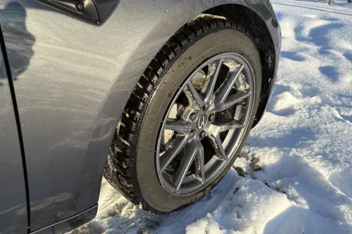 Sudraba automa&scaron;īnas priek&scaron;ējais ritenis sniegā.