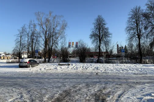 Ziemas ainava ar sniegotu ceļu un kokiem skaidri zilās debesīs.