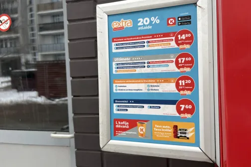 Plakāts ar auto mazgā&scaron;anas pakalpojumu cenām pie sienas.