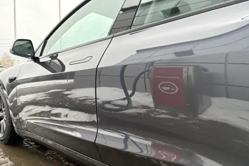 Melna automa&scaron;īna ar sniegotu zemes virsmu pie automazgātavas.